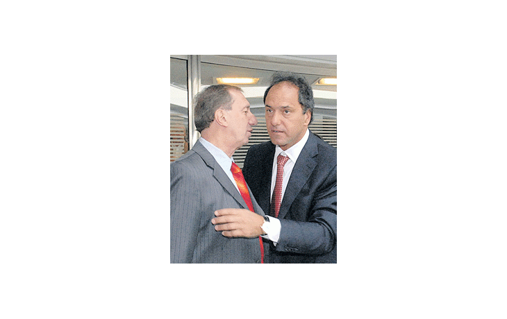 Daniel Scioli promociona su gabinete (ayer se mostró en TV con su futuro secretario de Deportes, Carlos Bilardo) mientras negocia para asumir con respaldo legislativo y paz gremial.