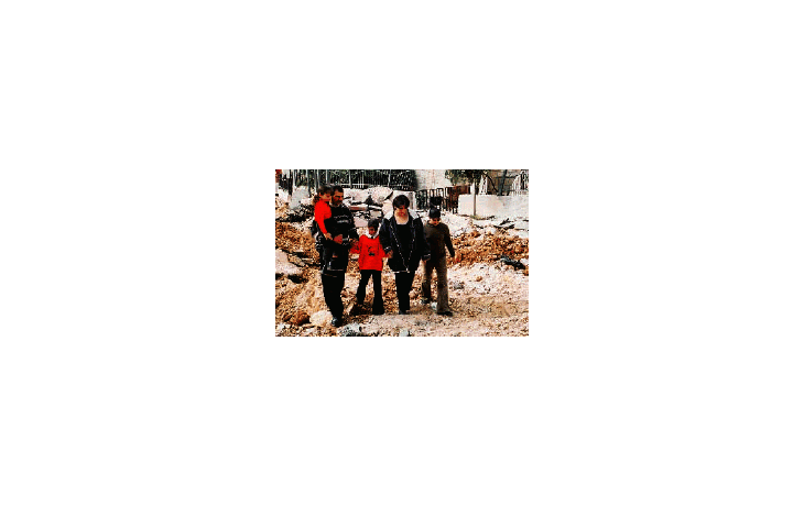 ámbito.com | La familia palestina Zeidan pasa delante de la casa que debió alquilar en Belén, Cisjordania, tras haber sido destruida la suya por obuses israelíes.