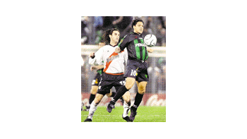 Cristian Gómez para la pelota ante la mirada de Guillermo Pereyra.