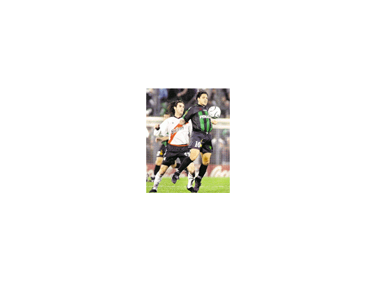 Cristian Gómez para la pelota ante la mirada de Guillermo Pereyra.