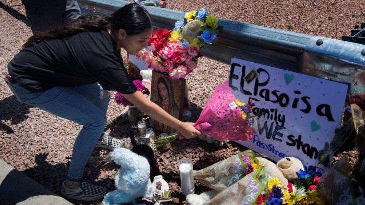 Una mujer deja flores en homenaje a las víctimas del tiroteo de El Paso.