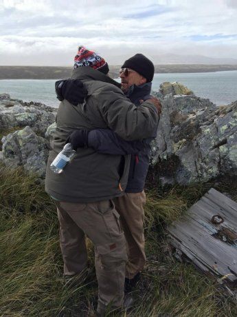 Los veteranos Juan Leyes y Daniel Marzano, abrazados sobre el pozo que hace 38 años fue la trinchera donde lucharon.