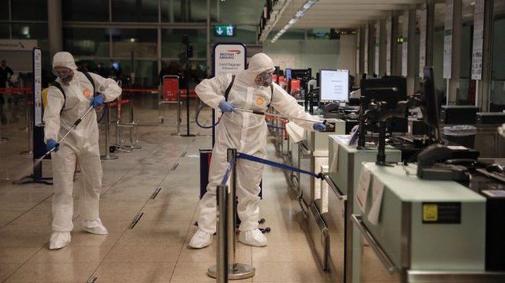 Trabajadores de la sanidad desinfectan el hall del aeropuerto de Barcelona.