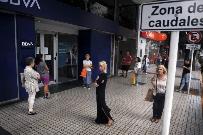Buenos Aires: cajeros automáticos de distintos bancos lucen colas para la extracción de dinero, aunque respetando la distancia recomendada para evitar el contacto.