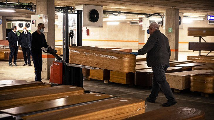 Dos trabajadores trasladan uno de los cuerpos a un coche que se dirige al crematorio de Montjuic, el único habilitado en toda la ciudad.