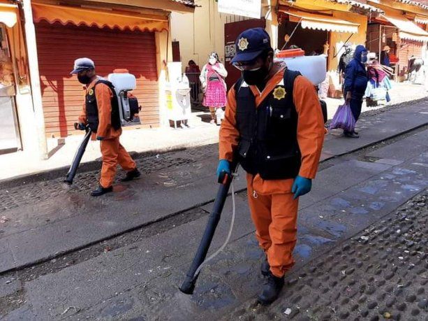 Trabajadores sanitarios de Cusco, Perú, realizan tareas de desinfección en la calle.