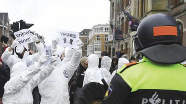 RESISTENCIA. Un manifestante sostiene un cartel que dice “libertad” durante la protesta que se realizó ayer en Ámsterdam contra las nuevas medidas de restricción sanitaria en Países Bajos.