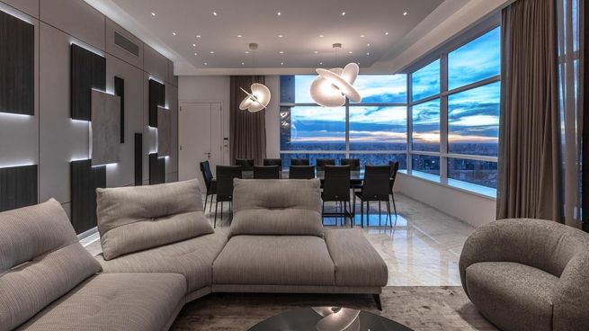 Amplio living con ventanales de piso a techo y vistas abiertas al skyline, en un penthouse que combina diseño contemporáneo, doble altura y terminaciones de alta gama