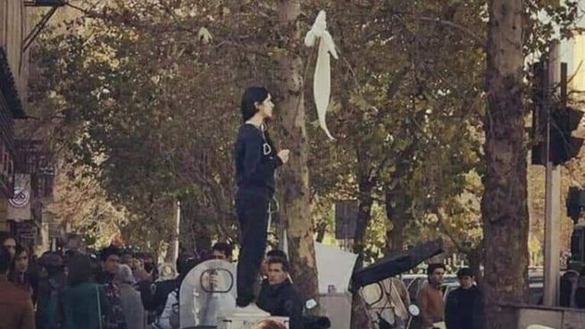 Una mujer sostiene su velo durante una de las protestas ocurridas en los últimos años en Irán.&nbsp;