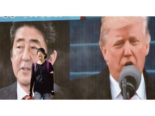 DOS ANTE UN DILEMA. Una mujer camina en Tokio frente a una pantalla gigante que muestra a Shinzo Abe y a Donald Trump. Las opciones inmediatas de ambos para contener a Corea del Norte son escasas.