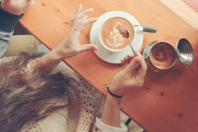 Una mujer revuelve su café en una pausa cotidiana, en una cafetería del centro porteño Una mujer revuelve su café en una pausa cotidiana, en una cafetería del centro porteño
