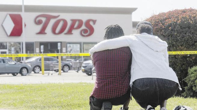 EL DÍA DESPUÉS. Residentes de Buffalo, Nueva York, lloraban ayer a las víctimas del ataque racista del sábado, atribuido al joven Payton Gendron, de 18 años.