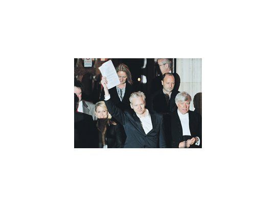 Julian Assange muestra el documento por el que la Justicia británica le concedió la libertad en espera de que culmine el proceso de extradición iniciado por Suecia. Le fijaron una fuerte fianza, le colocaron una pulsera electrónica y lo obligan a presentarse periódicamente en una comisaría.