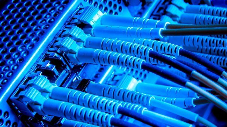 Primer plano de un cable de fibra óptica con múltiples núcleos luminosos.