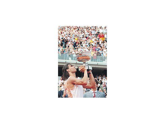 Rafael Nadal levanta el trofeo tras ganarle al suizo RogerFederer la final en Roland Garros. El mallorquín obtuvo eltítulo por tercera vez consecutiva.