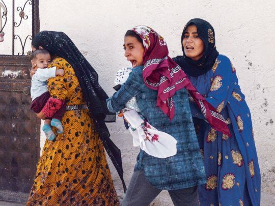 Pánico. Un grupo de mujeres turcas huyen con sus bebés en brazos tras un bombardeo en la ciudad fronteriza de Akcakale.