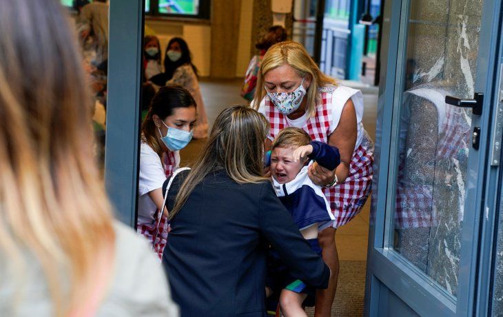 VOLVER. Maestras y niños (a partir de los 6 años) con barbijo y padres recelosos fueron ayer las marcas del reinicio de las clases presenciales en España. En la foto, el ingreso al Colegio Pureza de María, en Bilbao.