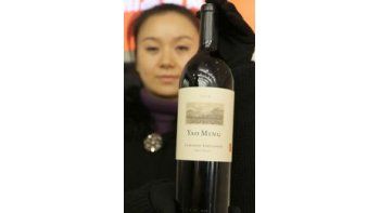 Botella. La mujer muestra el cabernet sauvignon que será subastado el domingo con una base de 7000 euros.