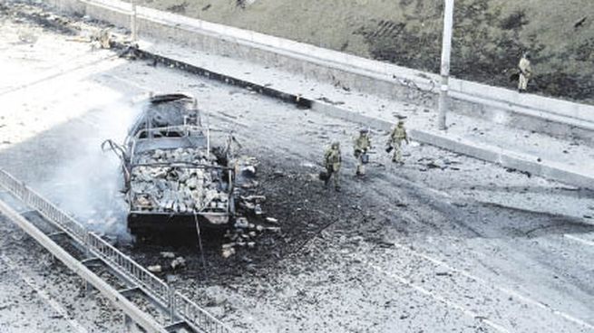 ALERTA. Soldados custodian uno de los ingresos de Kiev, mientras que imágenes satelitales muestran a un convoy militar ruso dirigiéndose a la capital ucraniana.