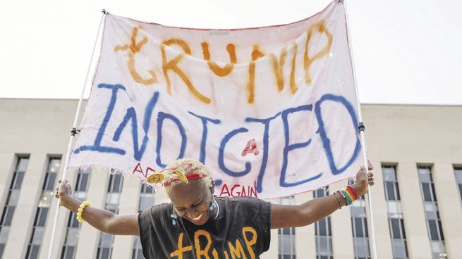ESPERA. Una manifestante sostiene una pancarta frente al tribunal federal donde se espera que el expresidente de EE.UU Donald Trump responda a los cargos.