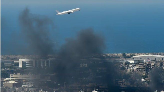 Un avión sale del aropuerto de Beirut este sábado sobre las columnas de humo, tras ataques israelíes en el barrio Dahiye.