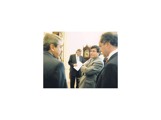 Carlos Zannini en una charla, en Olivos, con Aníbal Fernández y Daniel Scioli. Atrás, Néstor Kirchner.