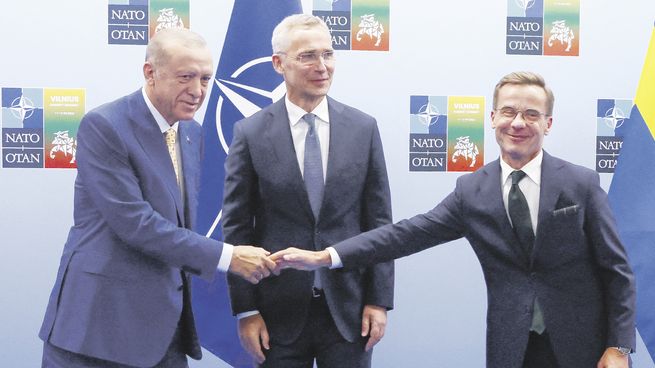 ALIADOS. El presidente turco, Tayyip Erdogan, y el primer ministro sueco, Ulf Kristersson, se dan la mano junto al secretario general de la OTAN, Jens Stoltenberg, en Vilnius, Lituania.