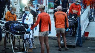 Personal de la Guardia Costera de Filipinas transporta bolsas con los restos mortales de los tripulantes fallecidos en el hundimiento del buque de carga M/V Devon Bay.