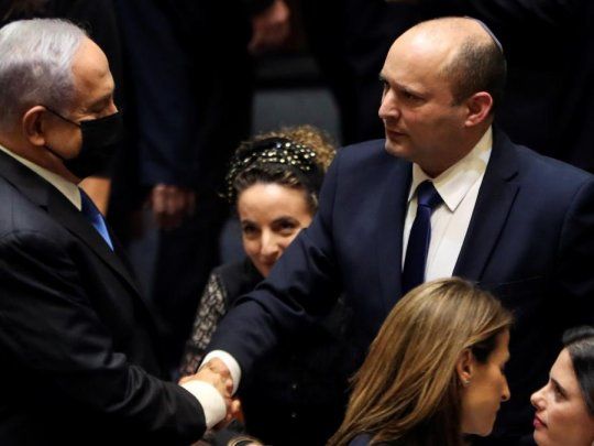 Benjamín Netanyahu estrecha la mano de su sucesor, Naftali Bennett.
