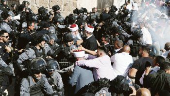 Cuerpo a cuerpo. Policías israelíes y fieles musulmanes forcejean en medio de generalizados disturbios en Jerusalén. Se teme una escalada de la violencia religiosa.