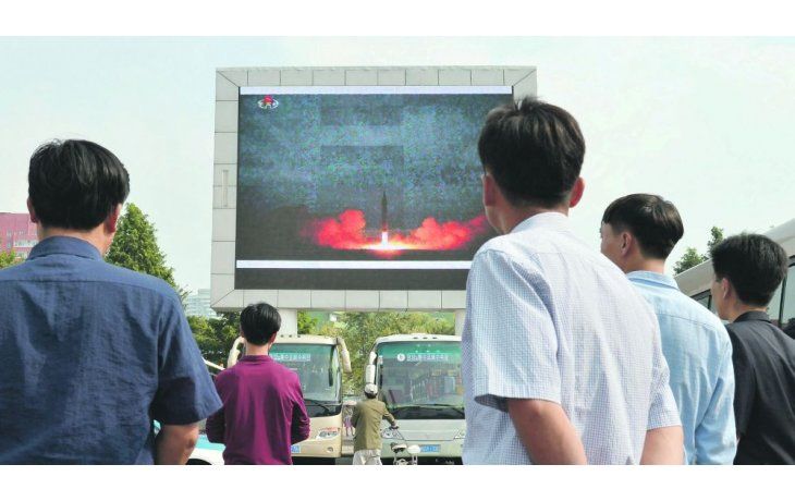 ámbito.com | ANUNCIO. Un grupo de norcoreanos observa el informe oficial del lanzamiento del misil que el martes sobrevoló Japón y que despertó la alarma internacional.