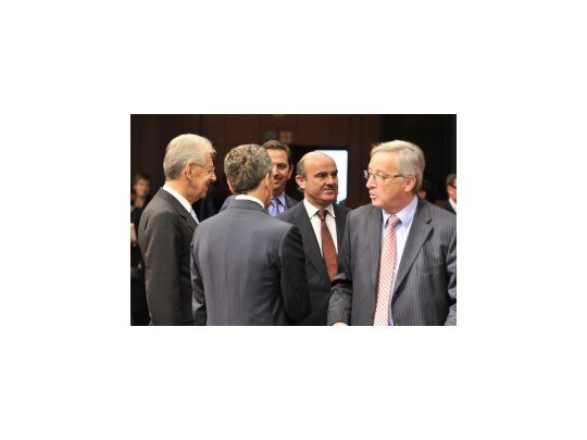 El presidente del Eurogrupo, Jean-Claude Juncker, (a la derecha) y a su espalda el ministro español de Economía y Competitividad, Luis de Guindos.