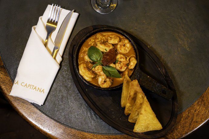 En La Capitana las gambas al ajillo se integran a una carta de perfil clásico en la que mandan los sabores definidos y las preparaciones de raíz. En La Capitana las gambas al ajillo se integran a una carta de perfil clásico en la que mandan los sabores definidos y las preparaciones de raíz.