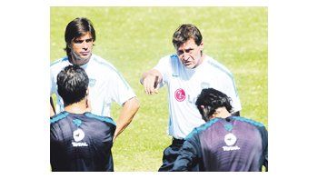 Julio César Falcioni les explica a los jugadores cómo quiere parar el equipo titular, mientras su ayudante Javier Sanguinetti escucha atentamente.