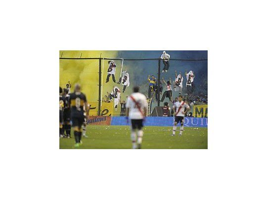Los hinchas de Boca subidos al alambrado disfrazados de fantasmas.