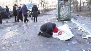 Un hombre llora junto al cuerpo de su madre, muerta en un bombardeo en Kiev.