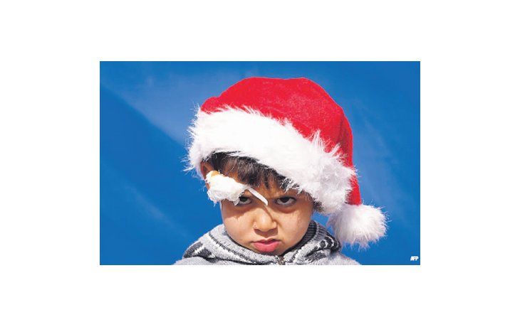 ámbito.com | Un niño cristiano iraquí, herido durante la ola de violencia yihadista que azota al país, luce un gorro de Papá Noel en  la ciudad de Arbil, territorio kurdo.
