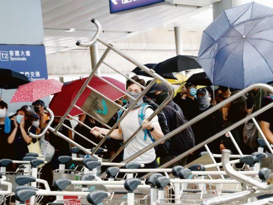 In crescendo. Los manifestantes prodemocracia armaron barricadas en el aeropuerto de Hong Kong con los carritos para transportar valijas y destruyeron varias cámaras de seguridad.