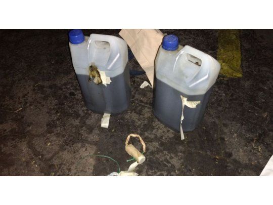 EVIDENCIA. La Policía halló dos bidones con combustible, mechas y pólvora entre los autos que se encontraban estacionados frente al ministerio, dos de los cuales terminaron en llamas.
