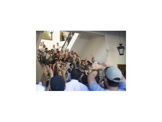 Policias de civil y familiares deliberan en la casa de gobierno provincial donde irrumpieron para hacer sus reclamos salariales.