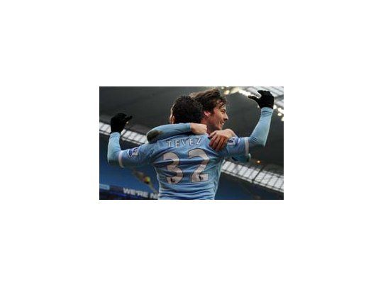 Silva abraza a Tevez en su 50° gol con la camiseta de Manchester City.