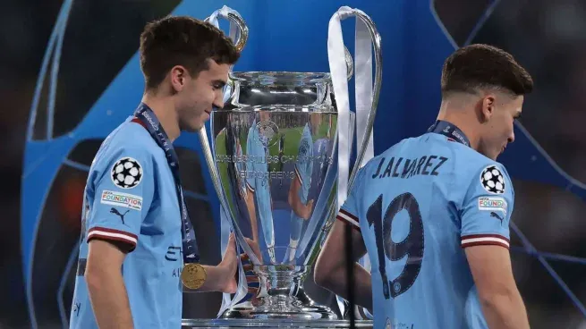 Sonrisa y beso. Máximo Perrone junto a Julián Álvarez y la medalla de campeón de la Champions League colgada en su cuello.&nbsp;