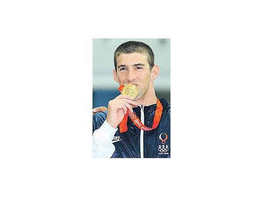Michael Phelps besa la segunda medalladorada conquistada en Pekín.