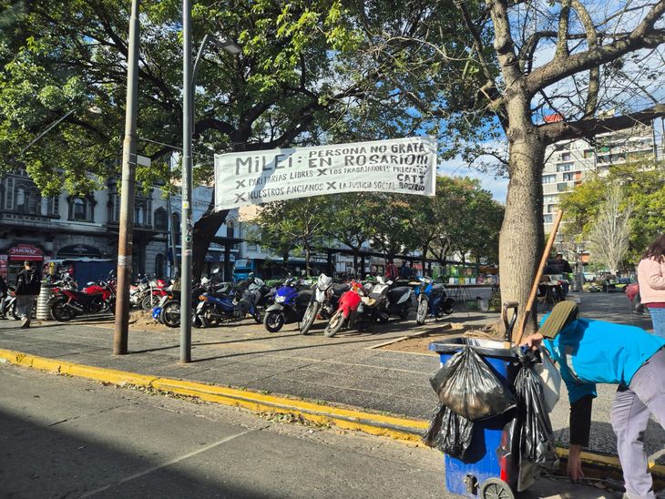 En las cercanías de la Bolsa de Comercio de Rosario, un pasacalles declara a Javier Milei "persona no grata". 