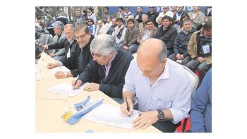 Omar Plaíni (canillitas), Guillermo Pereyra (petroleros), Hugo Moyano y Gerónimo Venegas (rurales) firman el petitorio por asignaciones y Ganancias durante el acto en Neuquén.