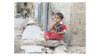 Un niño sentado en el portal de su casa en la ciudad de Homs, una de las más castigadas por el conflicto.