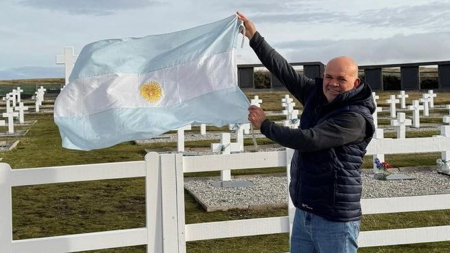 Aldo Leiva flamea la bandera argentina en el cementerio de Darwin.