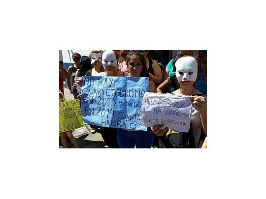 Algunas mujeres de los efectivos cordobeses reclaman con máscaras por temor a represalias a sus maridos. Exigen bono navideño. (Foto: gentileza Cadena 3)