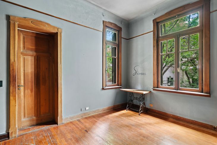 Uno de los dormitorios de la casona, con pisos de pinotea originales, aberturas de madera restauradas y vista al jardín arbolado del frente Uno de los dormitorios de la casona, con pisos de pinotea originales, aberturas de madera restauradas y vista al jardín arbolado del frente