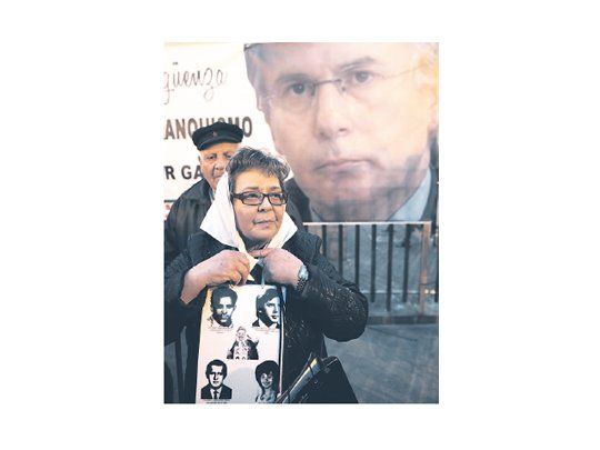 Una mujer con un pañuelo al estilo de las Madres de Plaza de Mayo sostiene un cartel con el rostro de desaparecidos, anoche en la Puerta del Sol.